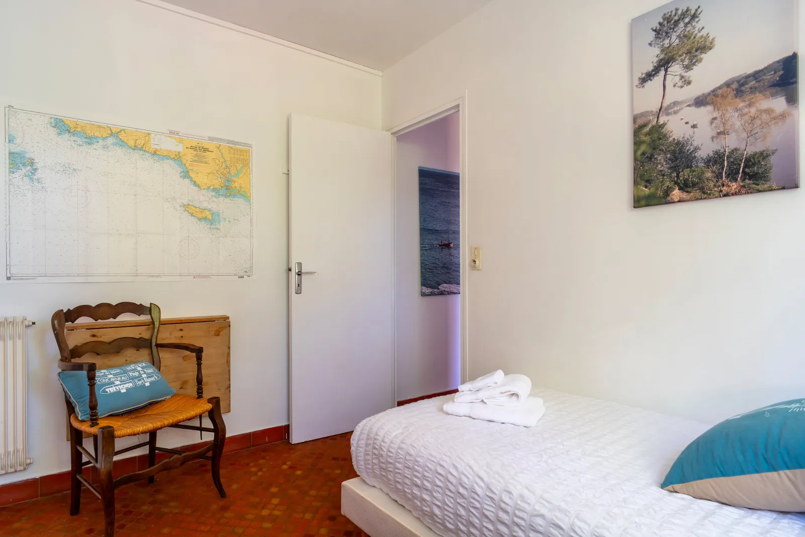 Chambre avec lit simple et décor marin