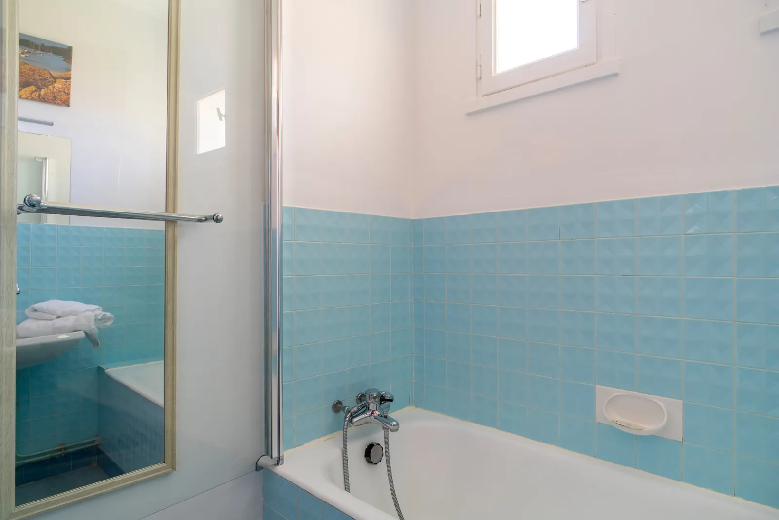 Salle de bain carrelée bleue avec baignoire